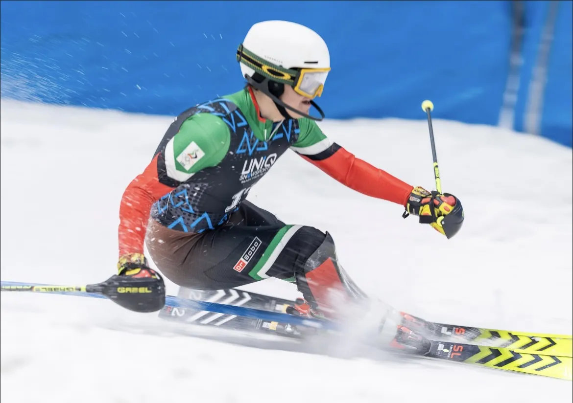 Alex Astridge carving a slalom turn at Ski Dubai in race suit and helmet